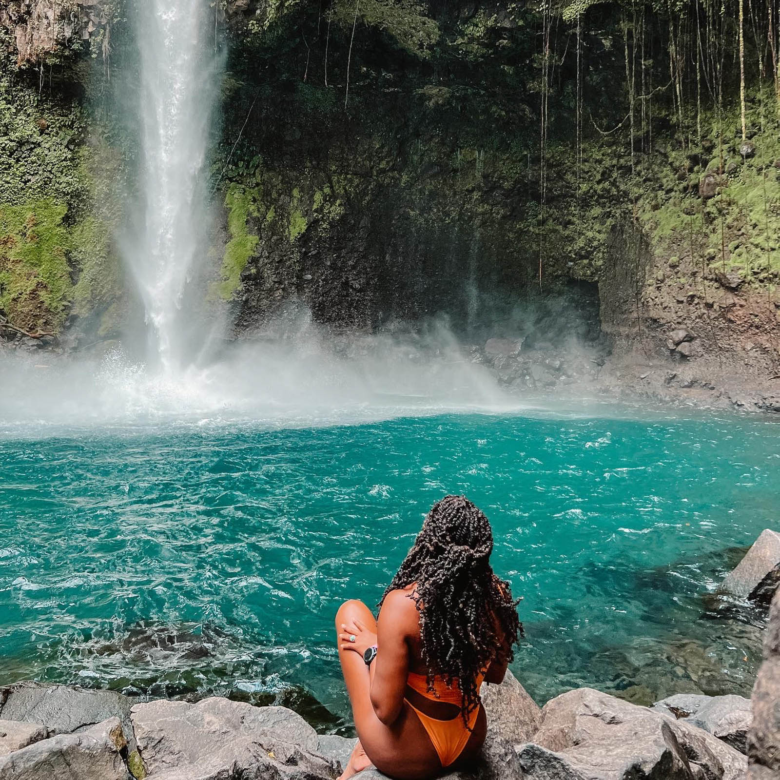 Girl sitting in front of La Fortuna waterfall in Costa Rica 