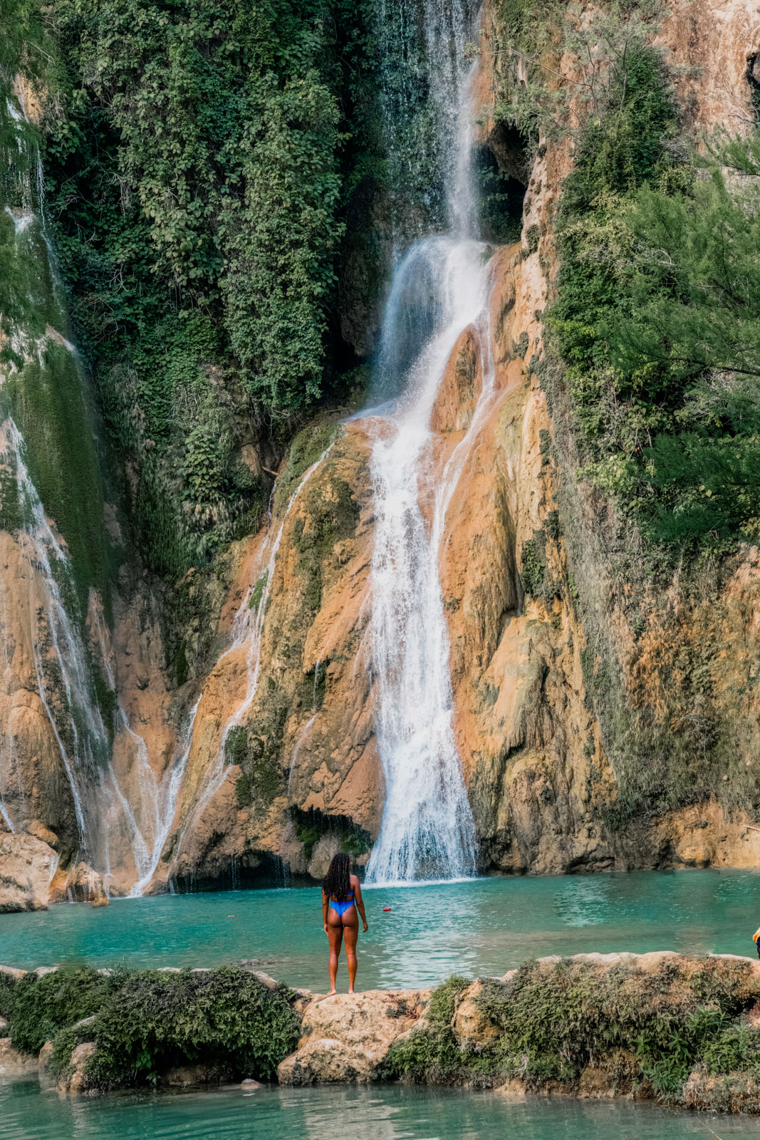 A girl standing in front of Cascada de Minas Viejas, one of the best waterfalls in Mexico.