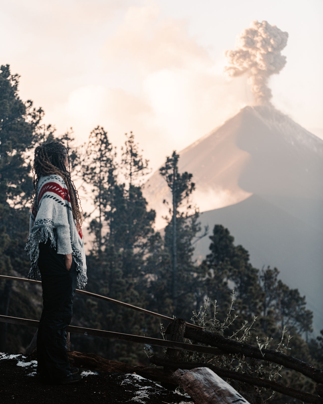 Black woman standing in front of erupting Fuego Volcano