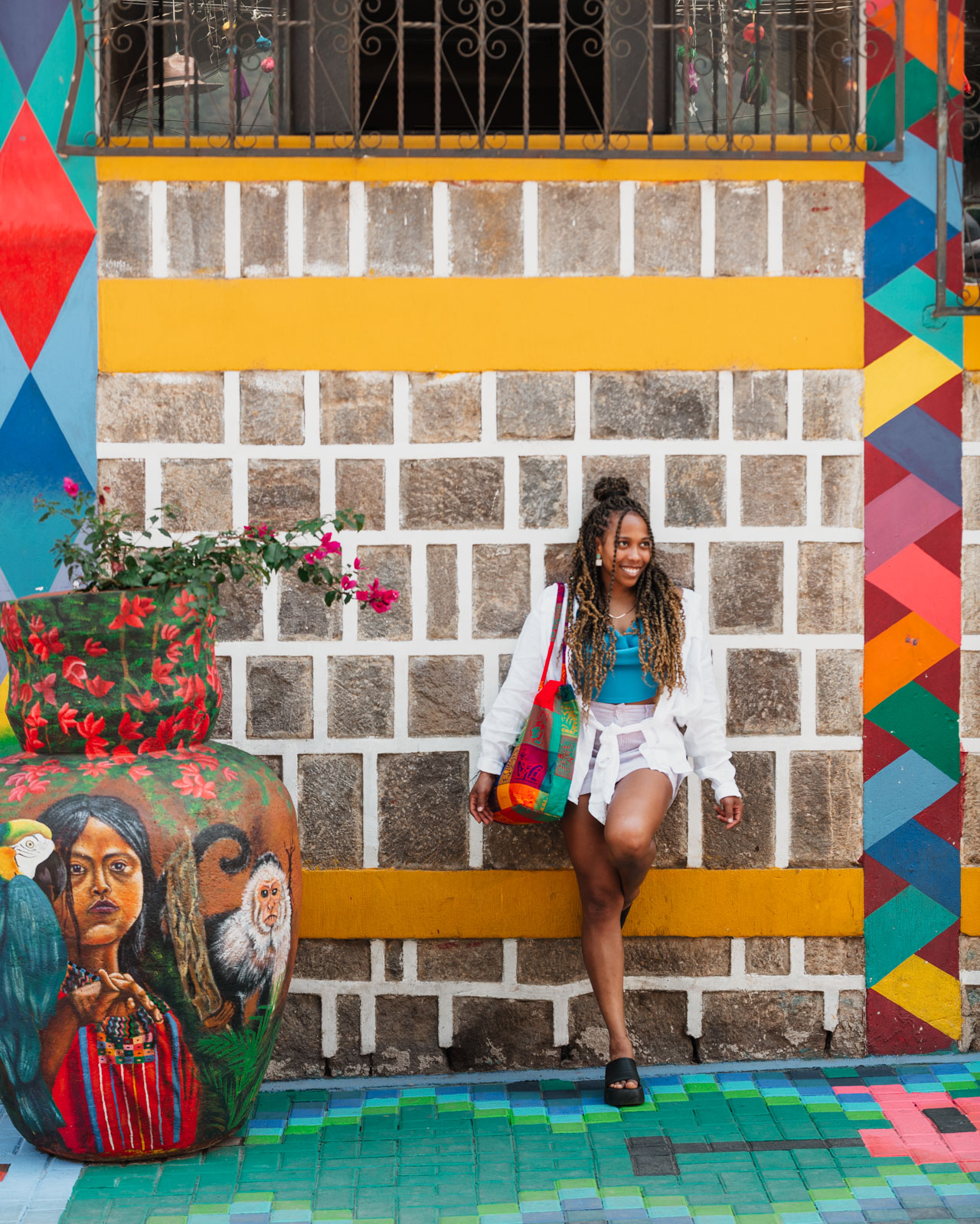 Woman standing in front of mural in San Juan Laguna, Lake Atitlan Guatemala