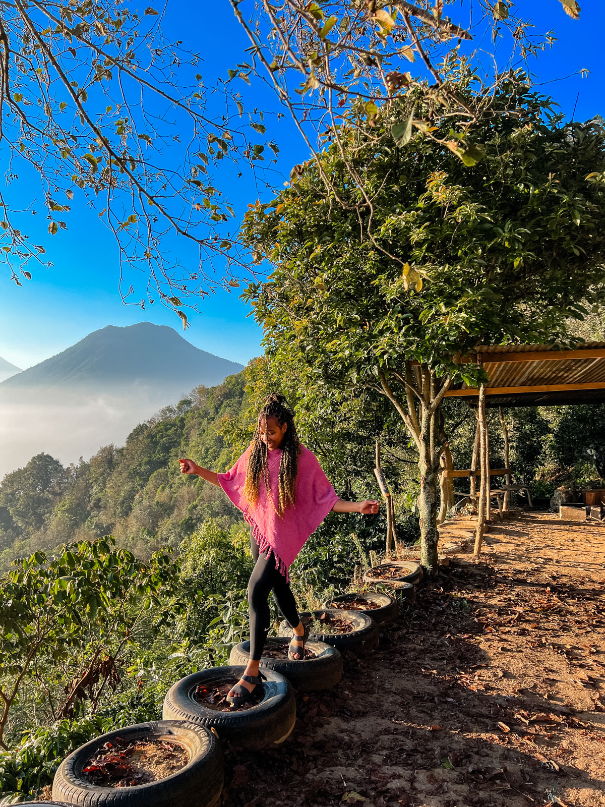 Woman walking on old tires at the edge of indian nose cliff in Lake Atitlan.